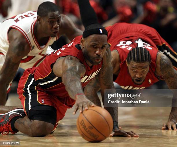 LeBron James and Udonis Haslem of the Miami Heat dive for a loose ball against Ronnie Brewer of the Chicago Bulls in Game Five of the Eastern...