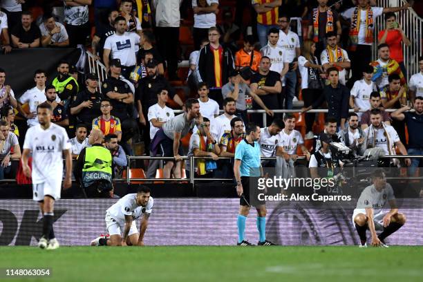 Ezequiel Garay and Gabriel Paulista of Valencia react as Arsenal score their fourth goal during the UEFA Europa League Semi Final Second Leg match...