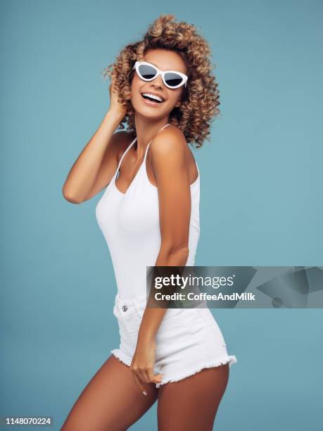 mooie jonge vrouw met krullend haar - sunglasses isolated stockfoto's en -beelden