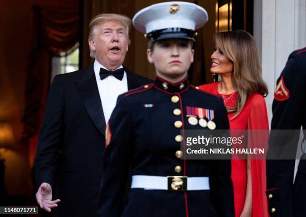 President Donald Trump and US First Lady Melania Trump react as they wait to greet Britain's Prince Charles, Prince of Wales and his wife Britain's...
