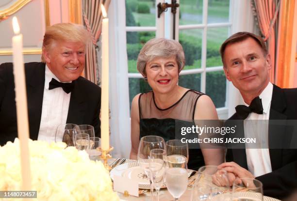 President Donald Trump talks with Britain's Prime Minister Theresa May and Britain's Foreign Secretary Jeremy Hunt during a dinner at Winfield House,...