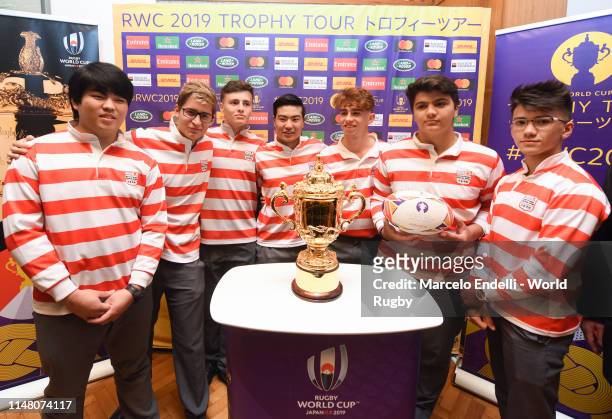 Rugby team from the Japanese Institute pose with the Webb Ellis Cup at a reception at the Residence of the Japanese Ambassador to Argentina during...