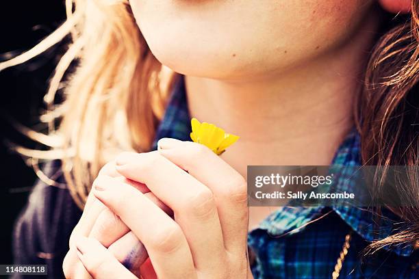 young girl holding buttercup flower - hahnenfuß stock-fotos und bilder