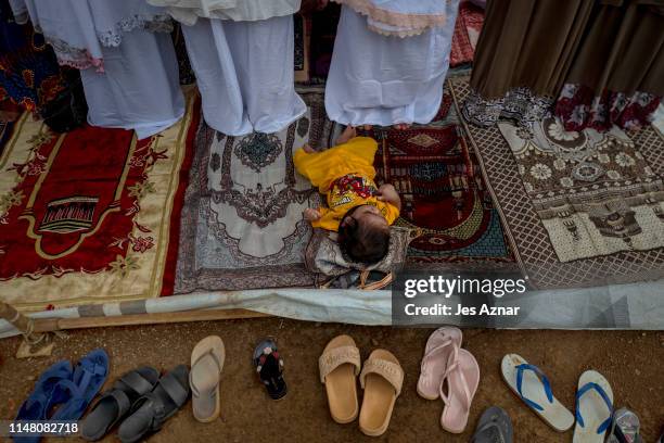 Displaced Marawi residents gather to celebrate Eidl Fitr in a makeshift prayer tent inside a shelter compound for evacuees on June 5, 2019 in Marawi,...