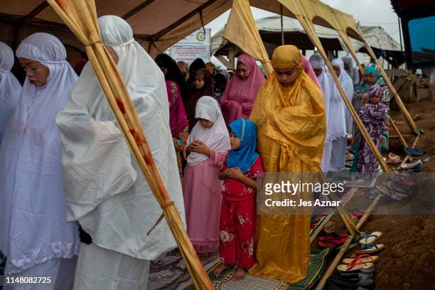 Displaced Marawi residents gather to celebrate Eidl Fitr in a makeshift prayer tent inside a shelter compound for evacuees on June 5, 2019 in Marawi,...