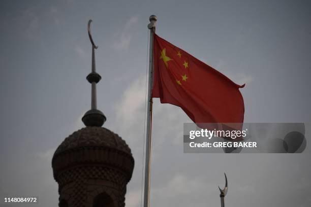 This photo taken on June 4, 2019 shows the Chinese flag flying over the Juma mosque in the restored old city area of Kashgar, in China's western...