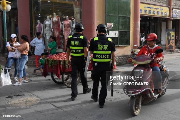 This photo taken on June 4, 2019 shows police officers patrolling in Kashgar, in China's western Xinjiang region. - While Muslims around the world...