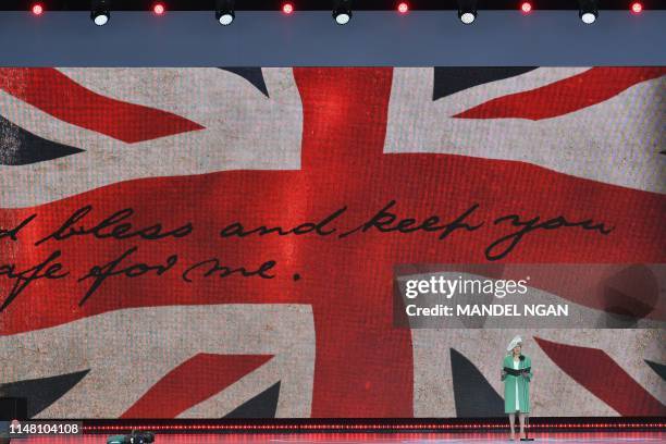 Britain's Prime Minister Theresa May stands and speaks as she reads a letter written by Captain Skinner, during an event to commemorate the 75th...