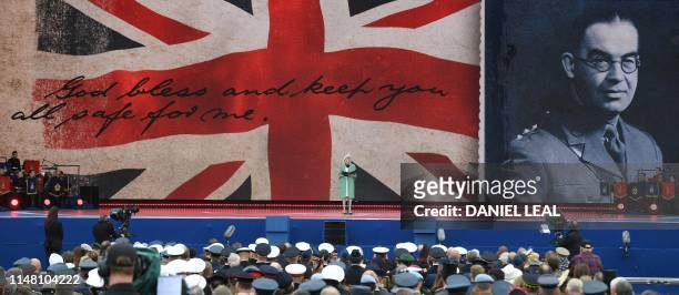 Britain's Prime Minister Theresa May stands and speaks as she reads a letter written by Captain Skinner, during an event to commemorate the 75th...