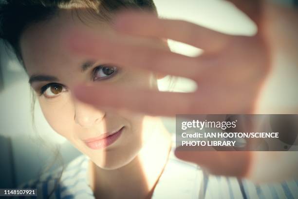 woman shielding her eyes from sun - blocking sun stock pictures, royalty-free photos & images