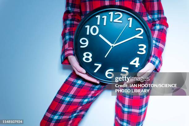 woman holding clock - biologische uhr stock-fotos und bilder
