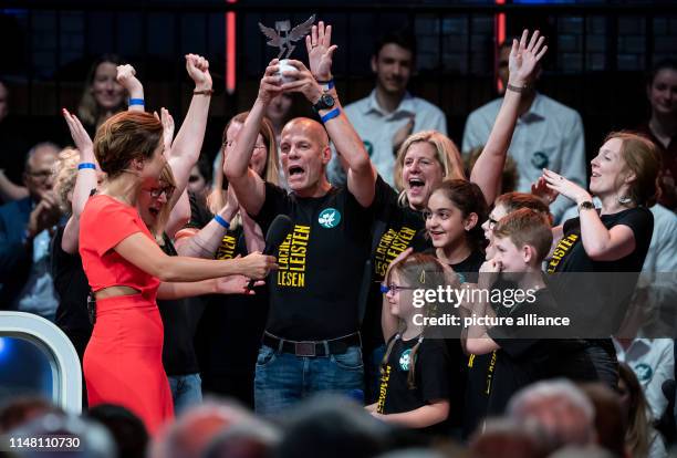 The moderator Eva-Maria Lemke hands over the main prize of the competition to headmaster Frank Wagner, teachers and pupils of the...