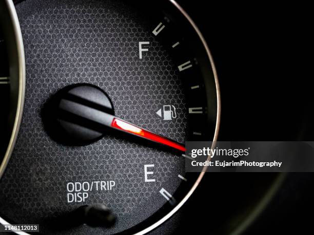 close up of car fuel gauge with red needle - gas tank stockfoto's en -beelden