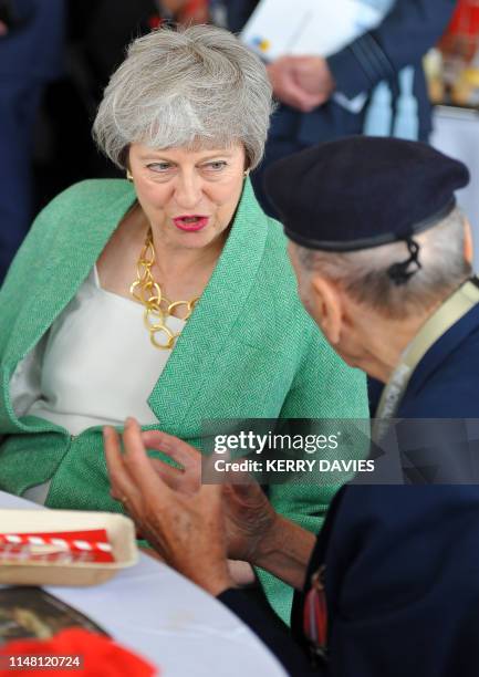 Britain's Prime Minister Theresa May reacts as she meets with veterans during an event to commemorate the 75th anniversary of the D-Day landings, in...