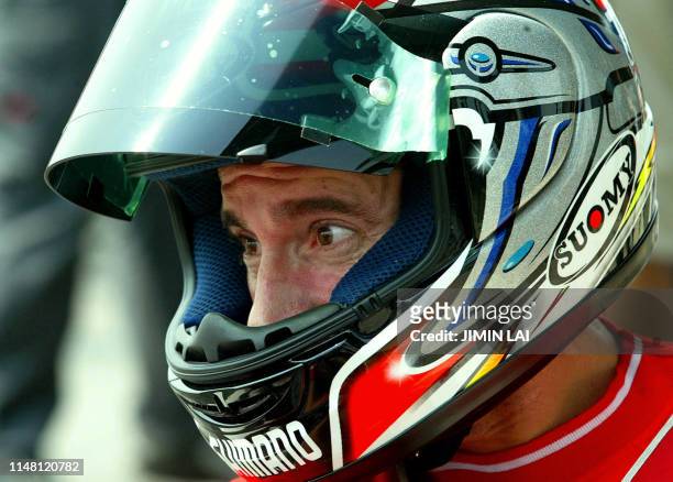 Italian Max Biaggi of Yamaha looks out from his helmet as he prepares for a fun kart race at the Sepang international circuit 10 October 2002, prior...