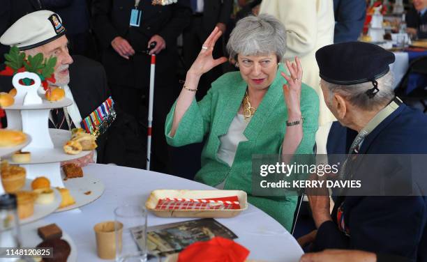 Britain's Prime Minister Theresa May reacts as she meets with veterans during an event to commemorate the 75th anniversary of the D-Day landings, in...