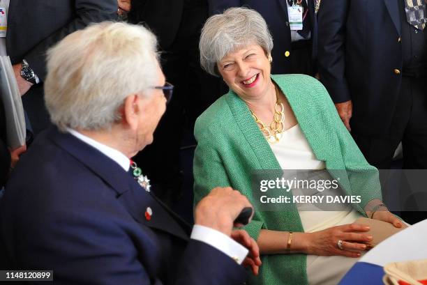 Britain's Prime Minister Theresa May reacts as she meets with veterans during an event to commemorate the 75th anniversary of the D-Day landings, in...