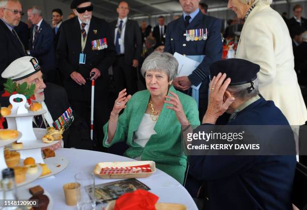 Britain's Prime Minister Theresa May reacts as she meets with veterans during an event to commemorate the 75th anniversary of the D-Day landings, in...