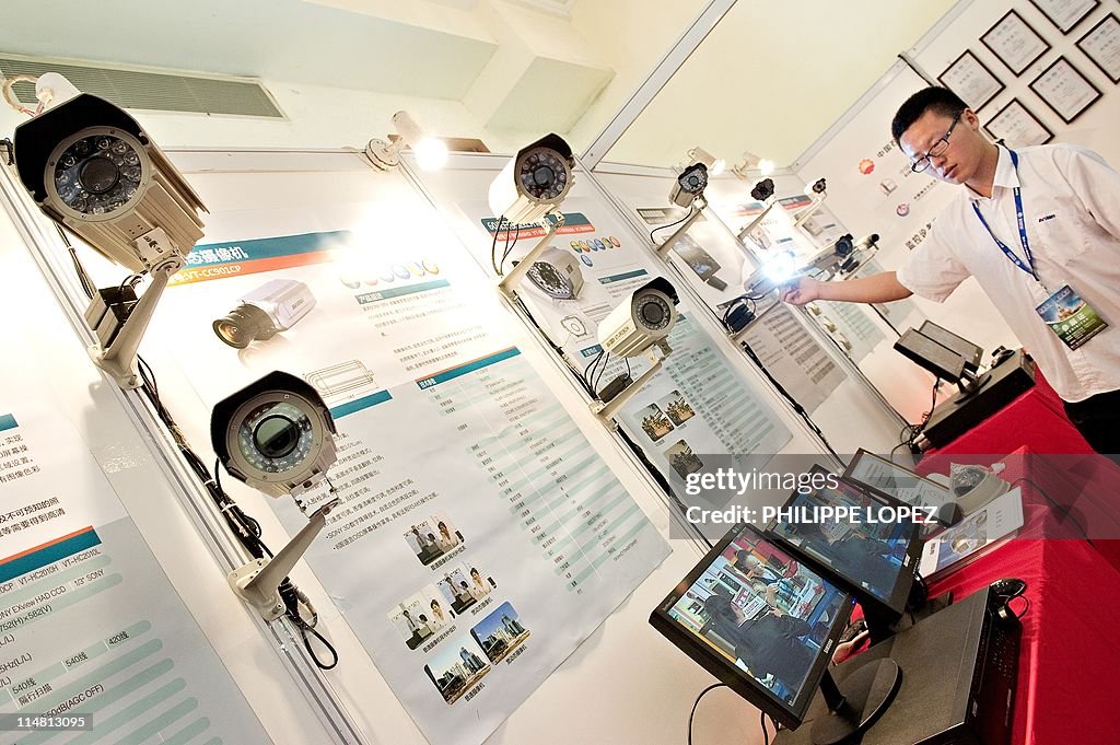 A man adjusts a surveillance camera disp