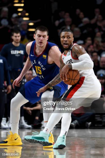 Damian Lillard of the Portland Trail Blazers does a spin move on Nikola Jokic of the Denver Nuggets during the second half of Game Six of the Western...