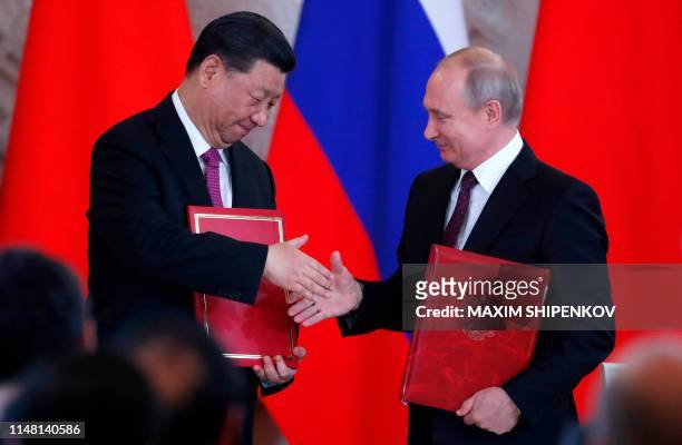 Russian President Vladimir Putin and his Chinese counterpart Xi Jinping attend a signing ceremony following their talks at the Kremlin in Moscow on...