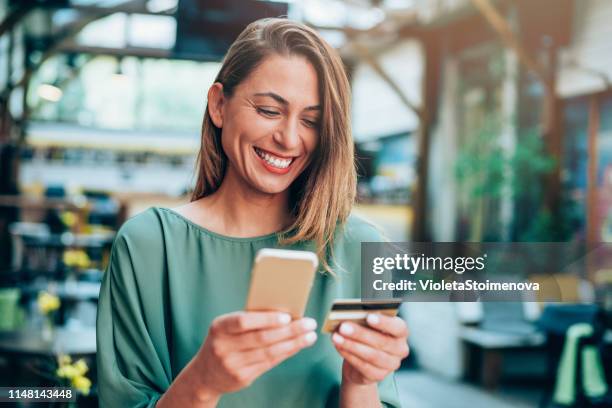 meisje houdt creditcard en sms'en - shop pay stockfoto's en -beelden