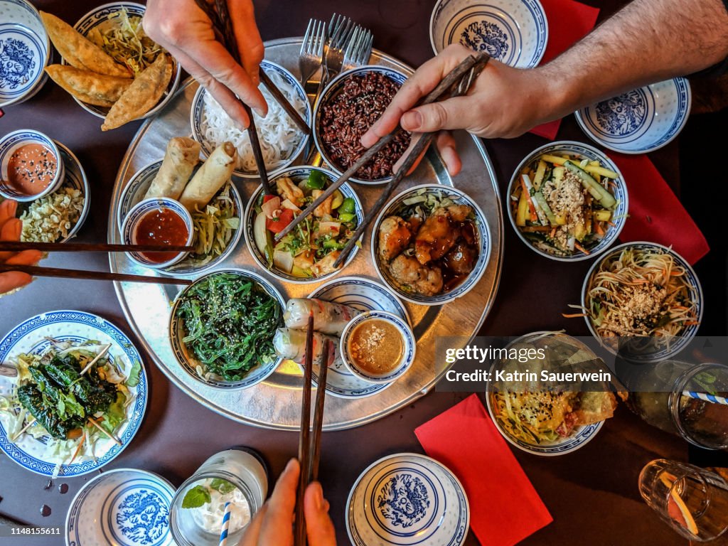 Vista de alto ángulo de personas que comen comida asiática