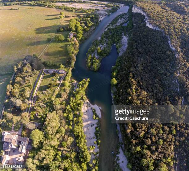 stunning aerial drone shot of the rhone river at sunrise. the river reflects the early morning sun and the river gorge is forested and green. - rhone stock pictures, royalty-free photos & images