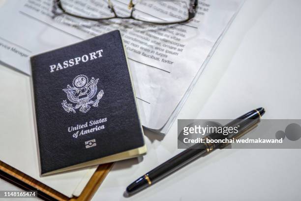 passport on the desk of an american businessman - immigration law stock pictures, royalty-free photos & images