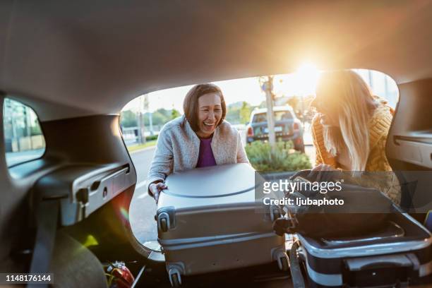 carefree girlfriends enjoying car trip - car leaving stock pictures, royalty-free photos & images