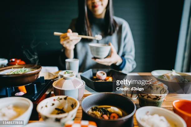 smiling young asian woman enjoying delicate japanese style cuisine with various side dishes, seafood and green tea in restaurant - 料亭 ストックフォトと画像