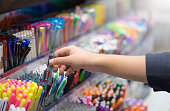 Close up hands choosing school stationery in the supermarket.