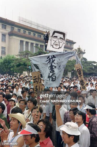 Chinese demonstrators raise a cartoon poster saying "Li and Yang dress in one pair of military controlled trouvers" on May 28, 1989 on the Beijing's...