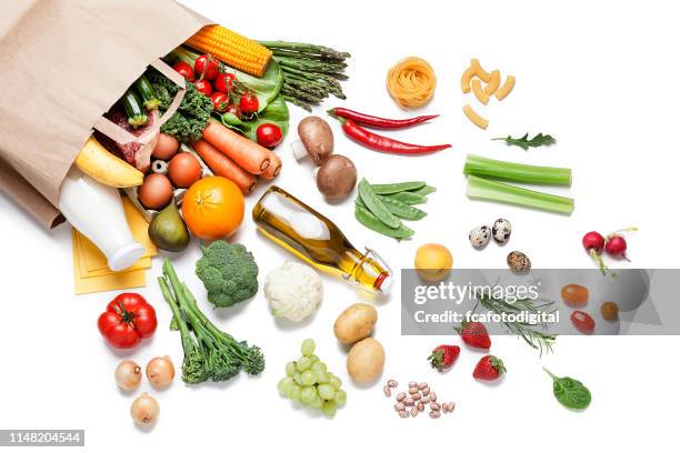 paper bag full of different food on white background - grocery bag stock pictures, royalty-free photos & images