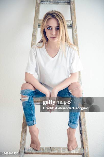 beautiful blue eyed female sitting on ladder - thinness obsession stock pictures, royalty-free photos & images