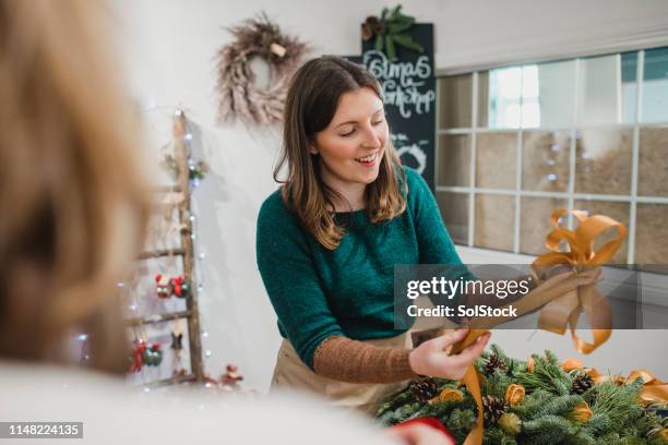 florist interacting with a customer - wreath making stock pictures, royalty-free photos & images