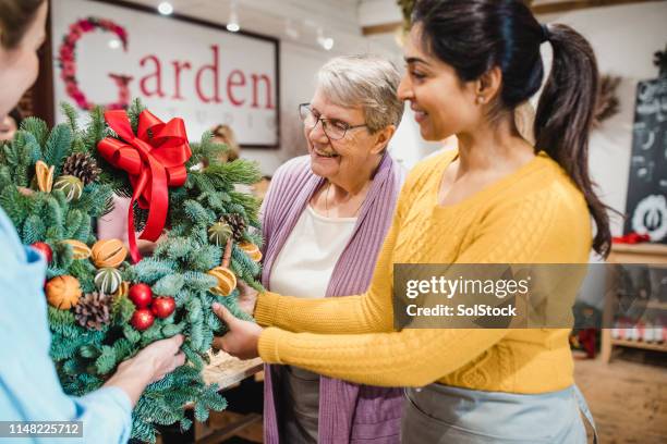 choosing a christmas wreath at the florist - small business saturday stock pictures, royalty-free photos & images