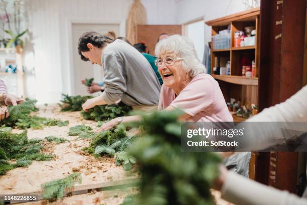 senior woman at a wreath-making workshop - christmas elderly stock pictures, royalty-free photos & images