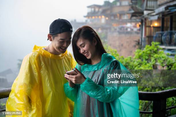 若いカップルは、九份でスマートフォンを見ている, 台湾 - ポンチョ ストックフォトと画像