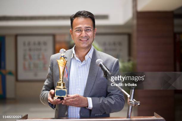 teacher raising trophy and giving speech - awards show imagens e fotografias de stock