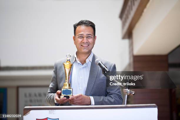 teacher raising trophy and giving speech - pride awards ceremony stock pictures, royalty-free photos & images