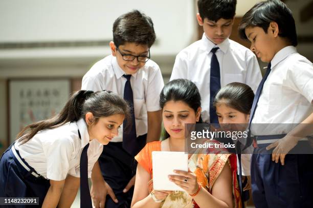 lehrer erklärt schülern mit digitalem tablet - indian school children stock-fotos und bilder