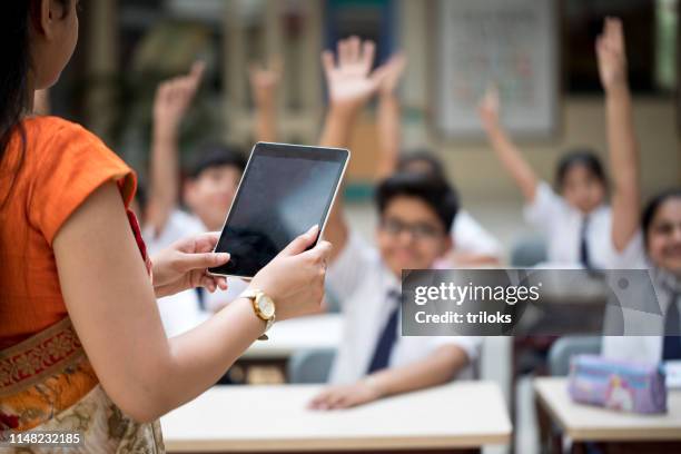 lehrer mit tablet-computer in der grundschule-unterricht - children india stock-fotos und bilder