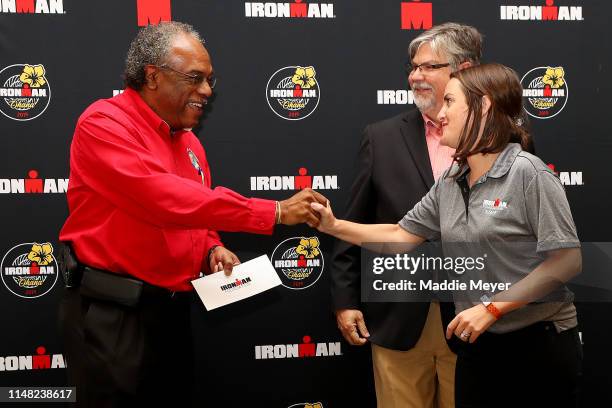 Community Relations Manager for the IRONMAN Foundation Michael Linn Sills, right, presents a check for Hurricane Michael relief to Director of...