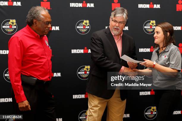 Community Relations Manager for the IRONMAN Foundation Michael Linn Sills, right, presents a check for Hurricane Michael relief to Director of...