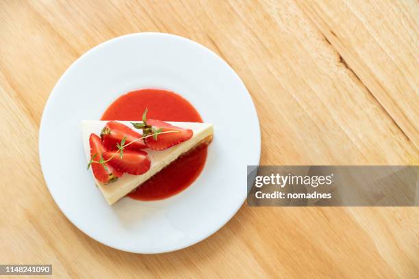 strawberry cheesecake on a white plate. - dessert photos et images de collection