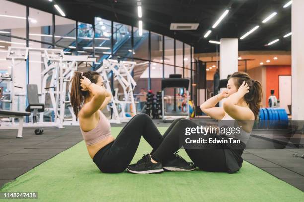 2 asian chinese female doing cross exercise sit up together - sister stock pictures, royalty-free photos & images