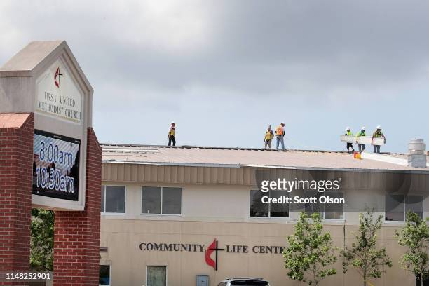Roofers repair the roof of a church that was damaged by Hurricane Michael on May 10, 2019 in Panama City, Florida. Seven months after the category...