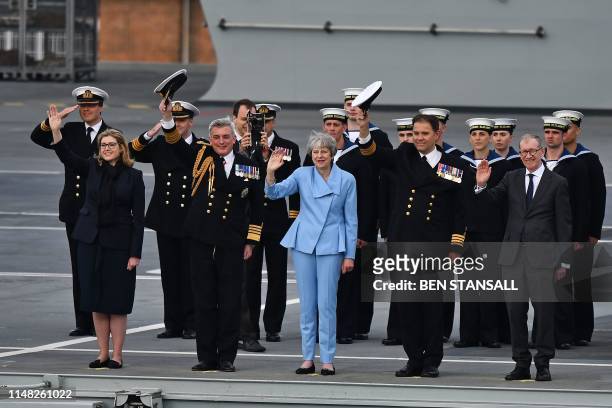 Britain's Prime Minister Theresa May waves beside Britain's Defence Secretary and Minister for Women and Equalities Penny Mordaunt on board the HMS...