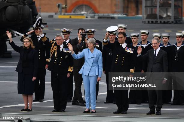 Britain's Prime Minister Theresa May waves beside Britain's Defence Secretary and Minister for Women and Equalities Penny Mordaunt on board the HMS...